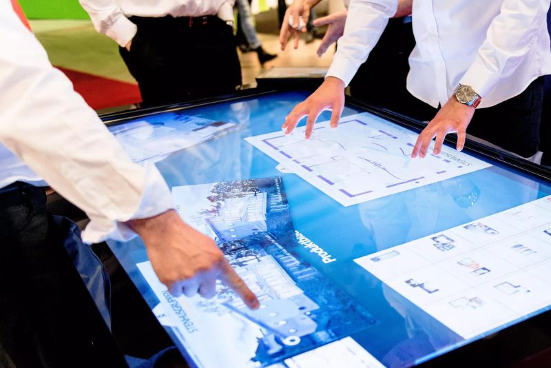 Multiple people in property development sector using multitouch on a large touchscreen panel