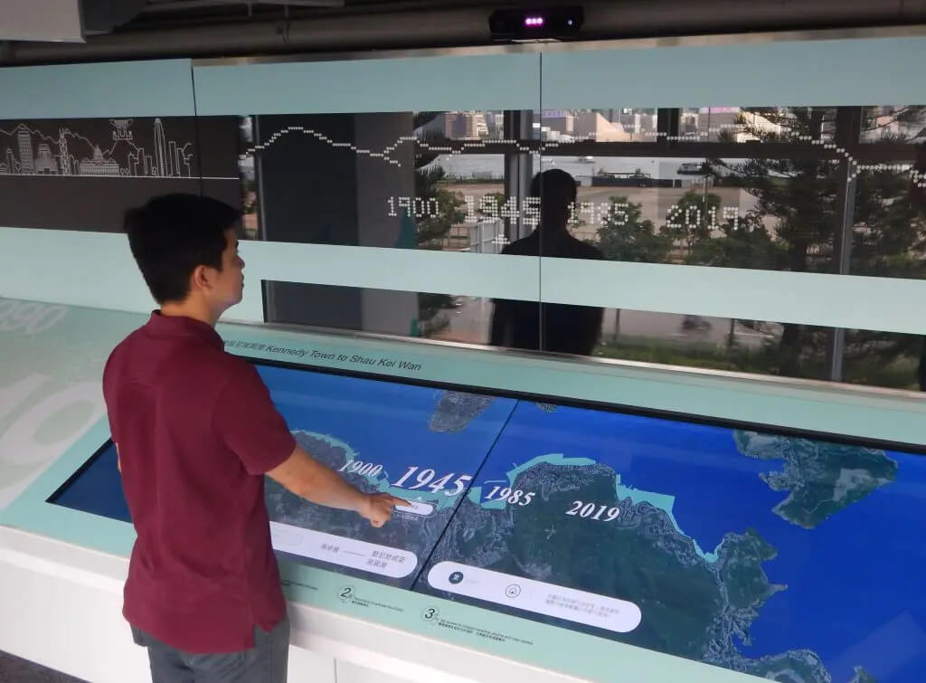 A person using a touchscreen to learn about geography
