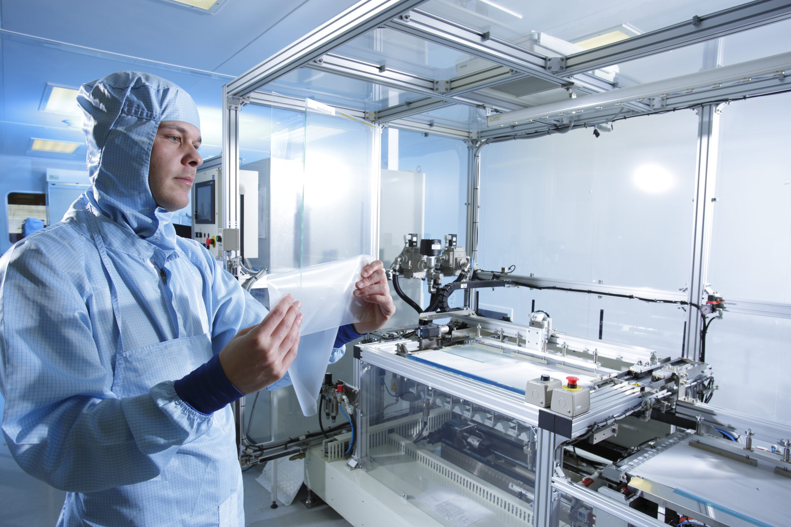 A Zytronic user holding up the lamination for the touchscreen in a factory