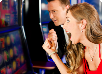 A lady winning at the casino using a touchscreen slot machine